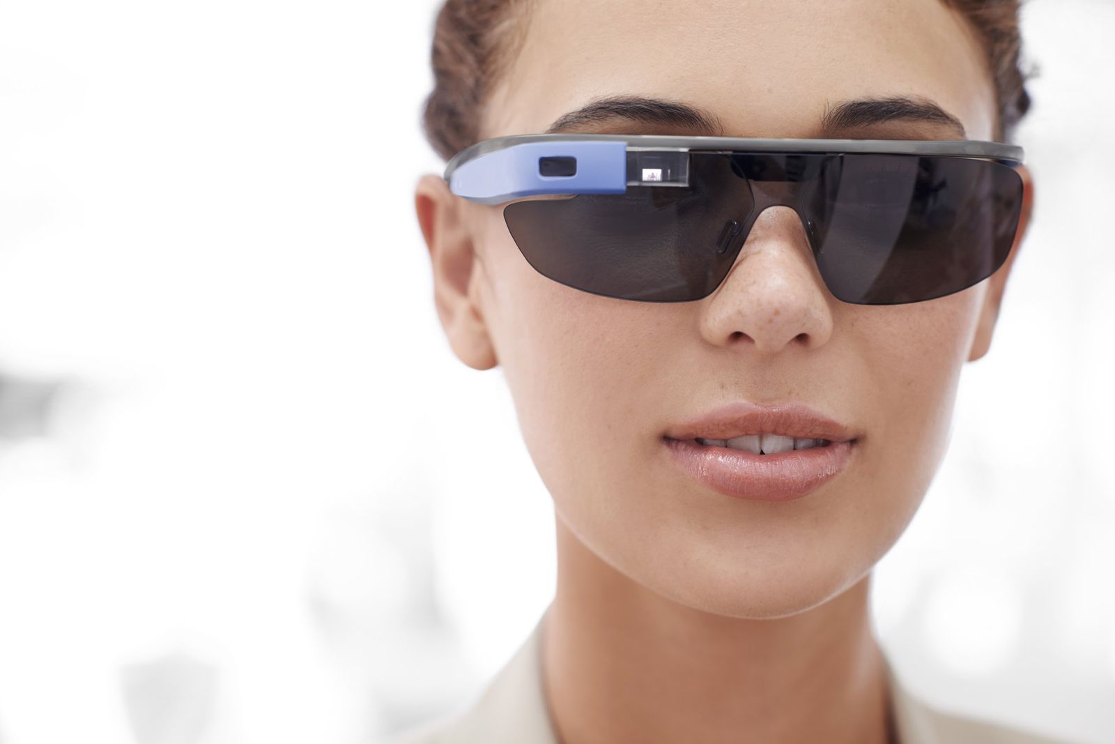 Close-up of a woman's face wearing dark smart glasses with a blue arm and a small camera and display.